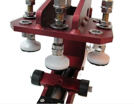 A red flame clamp with 3 prongs on a white background.