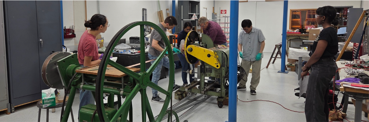 Interns working around machinery making magnets.