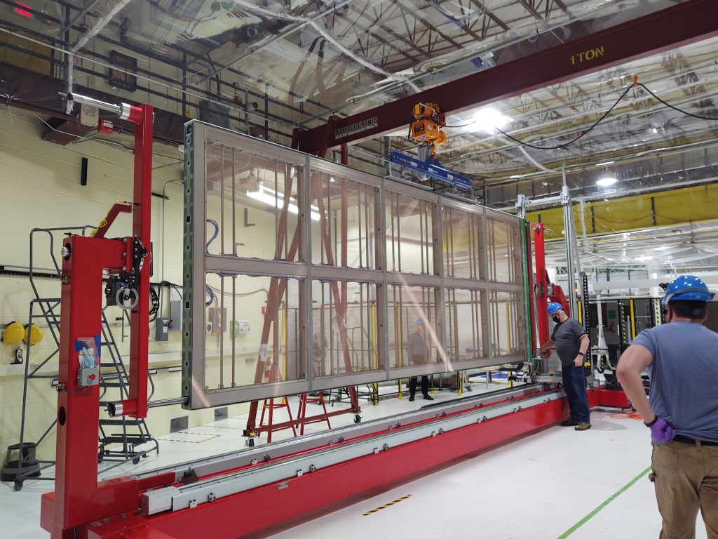 The DUNE APA in a large facility, with people working around it.