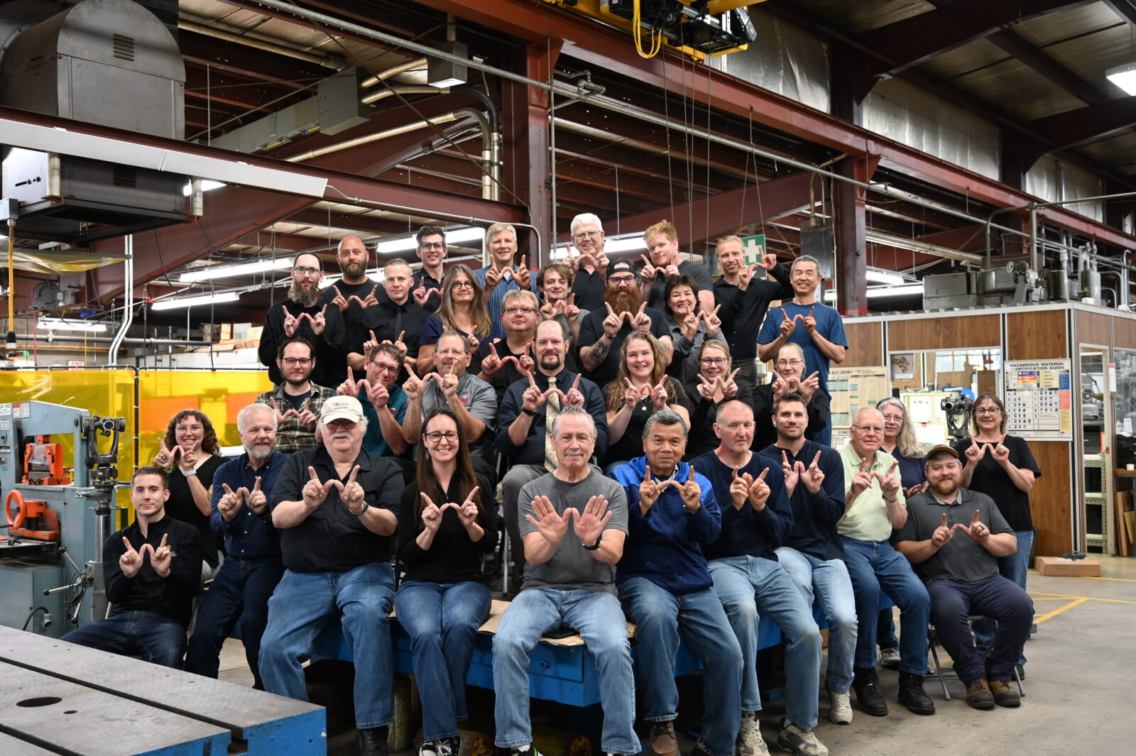 PSL Staff sitting in the shop, making W's for Wisconsin with their hands.